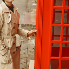 Obraz na płótnie Canvas Woman wearing rain coat near telephone box