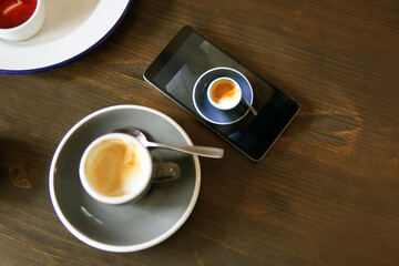 Coffee and mobile phone with a photo of coffee cup