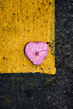 trodden pink heart-shaped donut on the asphalt