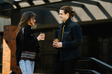 Pretty young couple drinking coffee on the street cafe having fun together outdoor