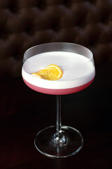 Pink cocktails at bar in nightclub party. Cocktails on black background in glass glasses.