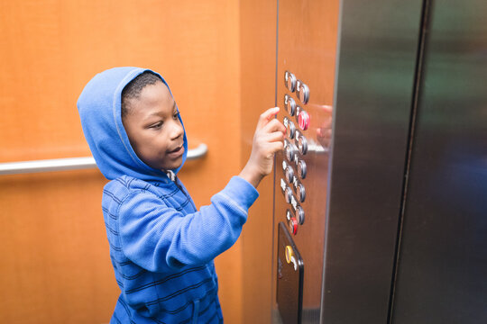 Black boy pushes elevator button