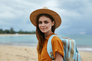 woman tourists in hat with backpack on island landscape