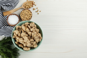 Flat lay composition with dried soy meat on white wooden table. Space for text