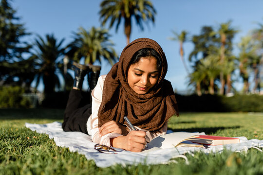 Muslim Woman Journals at Park