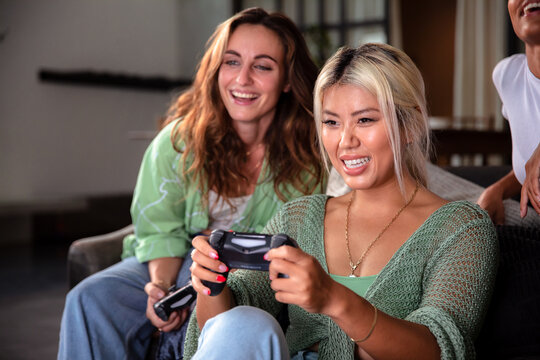 Group of girlfriends playing video games at home