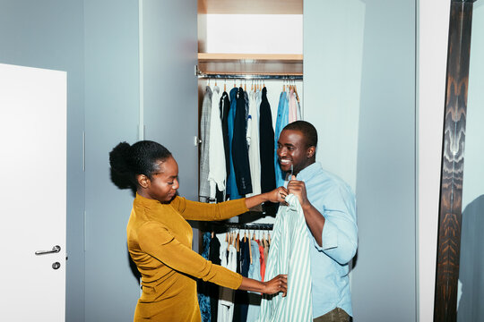 Woman Helping Man to Choose a Shirt 