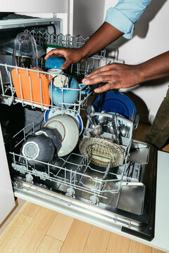 Man Taking out Dishes from a Dishwasher 