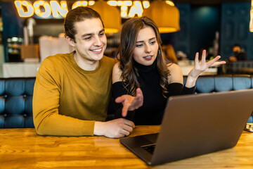 beautiful woman and handsome man hugging, using laptop and showing gestures make video call