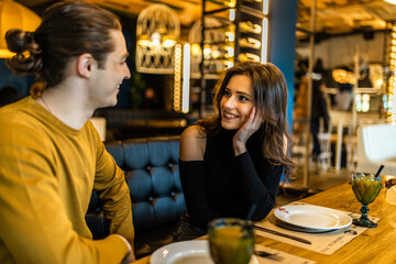 Young serious man having conversation with woman girlfriend sit at cafe table.
