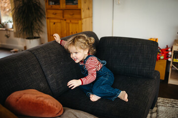 Girl jumping and having fun in the sofa 