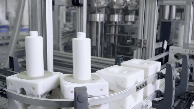 White plastic bottle on the conveyor. Clip. High technology Plastic bottle manufacturing industrial, Raw material plastic bottle production, precision plastic bottle blow method. 4K