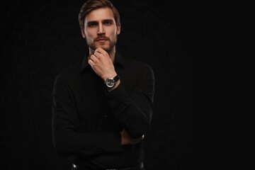 Elegant young handsome man in black suit. Studio fashion portrait
