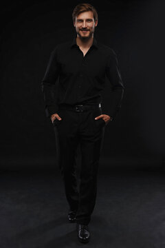 Young Man In Black Suit Full Body Portrait Against Black Background.