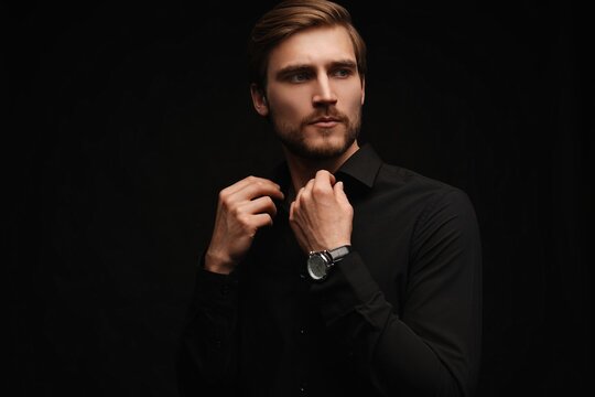 Elegant young handsome man in black suit. Studio fashion portrait