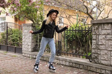 Young woman roller skating on spring day