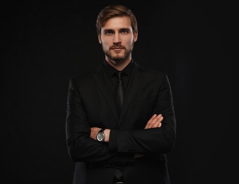 Elegant young handsome man in black suit. Studio fashion portrait