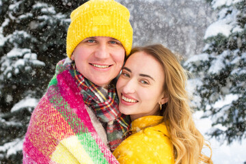 Portrait of stylish happy couple on snowy forest background