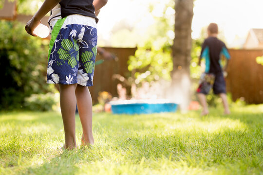  Boy cautiously stands back from water fight