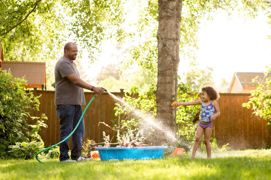 Father and daughter have water fight
