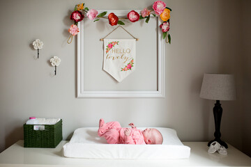 Crying baby girl lays on changing table