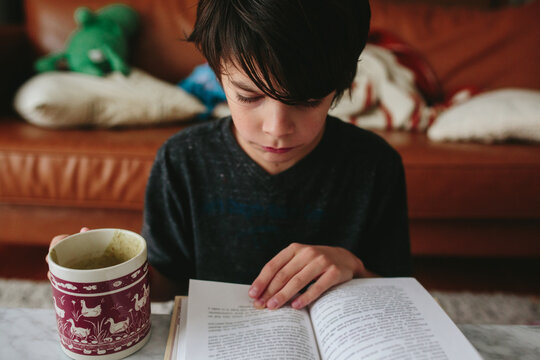 Close-up portrait of a girl sitting at a table reading a book