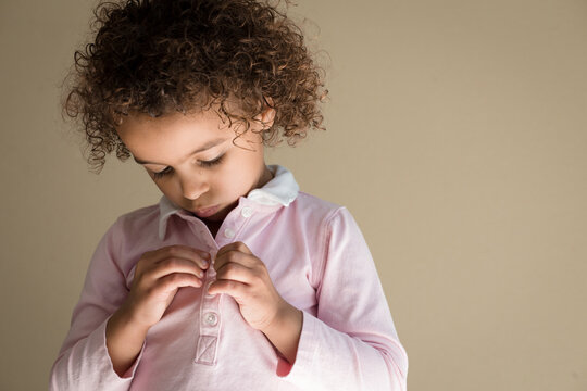Girl fastens tiny shirt buttons