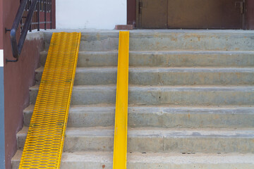 Yellow ramp on the stairs at the entrance of the house for the disabled or a baby carriage