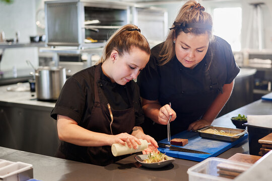 Chefs plating food in a fine dining restaurant kitchen