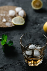 Whiskey with ice, ingredients on the background