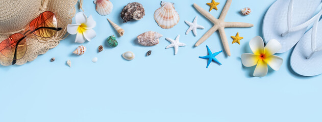 Summer beach background design concept with shells, hat, slipper on blue background.