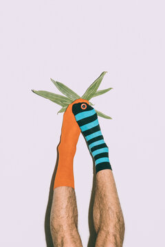 a man dressed in various colorful socks holds a string bean