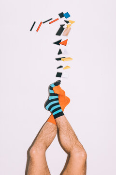 a man dressed in various colorful socks + colorful wooden shapes in free fall