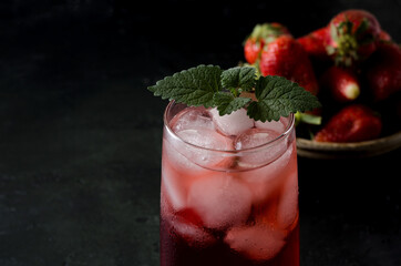 Drink of strawberries close-up in a glass glass on a dark background
