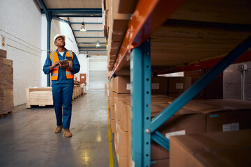 Portrait of african engineer inspector checking the stock in the warehouse using digital tablet