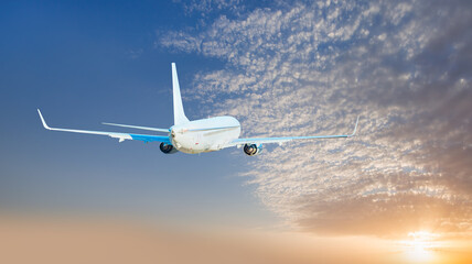 Airplane flying over tropical sea at sunset