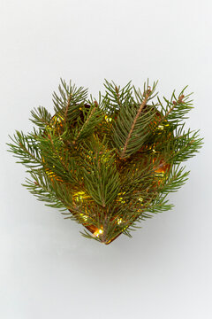 Heart shaped coniferous branches flat lay with festive twincle lights