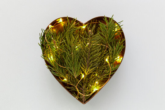 Heart shaped coniferous branches flat lay with festive twincle lights
