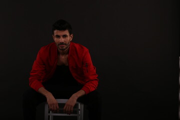 Fototapeta na wymiar Portrait of a man in red jacket on black background