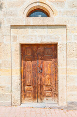 Fototapeta na wymiar Ancient wooden door on a stone made wall - Mustafapasa, Cappadocia