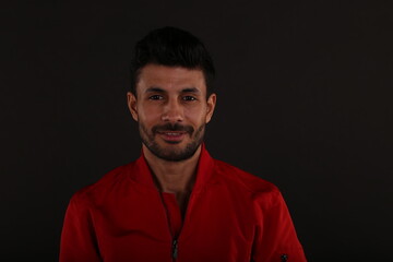 Portrait of a man in red jacket on black background