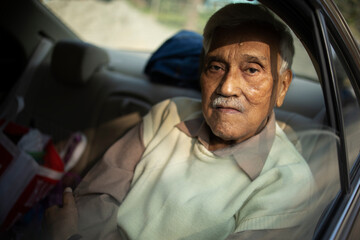 Senior Indian man portrait inside car