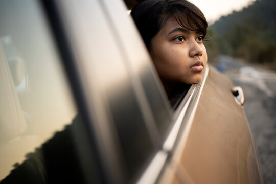 Teenage Indian girl looking outwards from a car