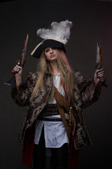 Attractive woman pirate with guns against dark background