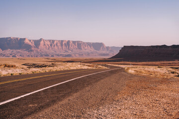 A picturesque empty road in Arizona through a desert of red rocks and rocks