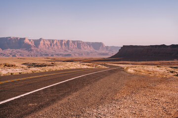 Fototapeta na wymiar A picturesque empty road in Arizona through a desert of red rocks and rocks