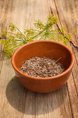Dill seeds in a bowl on a wooden table. Dill seeds in a bowl on a wooden table