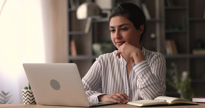 Indian female blogger working on new blog creates text on laptop. Journalist writing article while sit at cozy home office. Telecommute job, student prepare for exams use internet resources concept