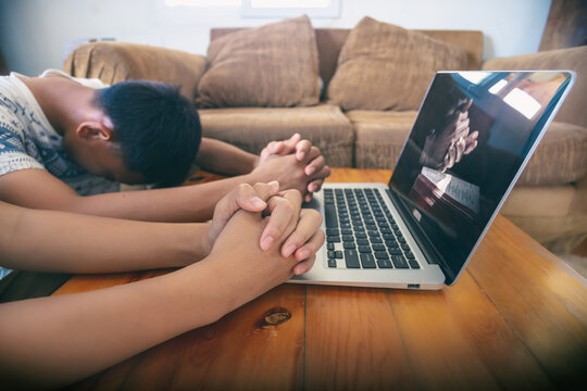 Two christians praying with computer laptop, Online live church for sunday service, Home church during quarantine coronavirus Covid-19, Focus hands.