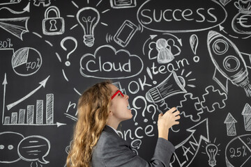 Young businesswoman against chalkboard with business sketch